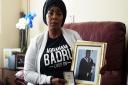 Ronke Badru, the mother of Abraham Badru who was shot dead in March 2018, holding a picture of her son and the bravery award he received in 2019