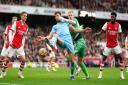Manchester City's Ruben Dias (left) and Arsenal goalkeeper Aaron Ramsdale battle for the ball