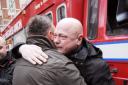 Tearful firefighter Alex Badcock is consoled by a colleague in January