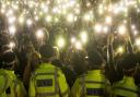 People in the crowd turn on their phone torches as they gather in Clapham Common, London, after the Reclaim These Streets vigil for Sarah Everard was officially cancelled.