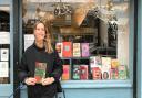Jo Heygate, Bookshop Manager at Pages of Hackney holds up the book Antiemetic for Homesickness by Romalyn Ante.