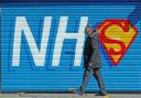 A man walks past a sign created in support of the NHS during the pandemic