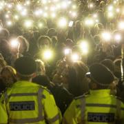 People in the crowd turn on their phone torches as they gather in Clapham Common, London, after the Reclaim These Streets vigil for Sarah Everard was officially cancelled.
