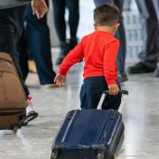 A young boy pulls a suitcase as refugees arrived from Afghanistan at Heathrow Airport