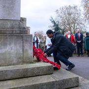A young man lays a poppy wreath at Hackney's 2021 Remembrance Sunday