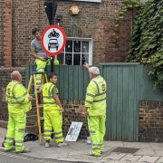 Workers installing signs for the Stoke Newington Church Street LTN, which will now allow Blue Badge holders exemption.