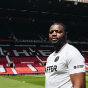 Hackney Wick owner Bobby Kasanga faces the camera at Old Trafford, the home of Manchester United